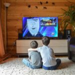 due ragazzini abbracciati di spalle che guardano la tv