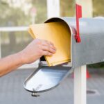 braccio che ritira posta dalla cassetta della posta
