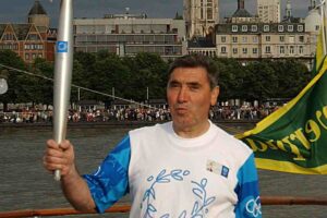 Eddy Merckx con la fiaccola olimpica